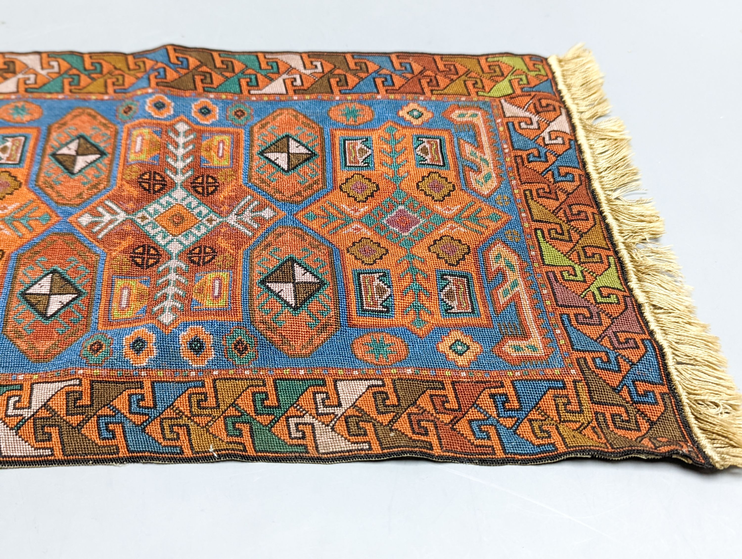 A Caucasian style petit point miniature rug 33x20cm